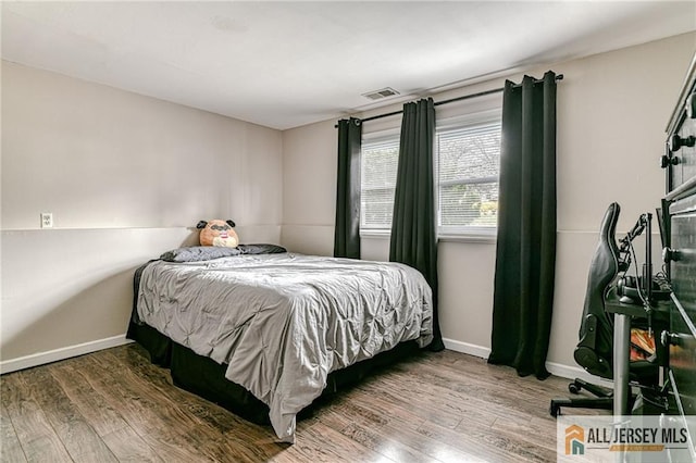 bedroom with wood finished floors and baseboards