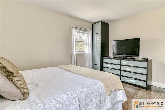 bedroom featuring wood finished floors and baseboards
