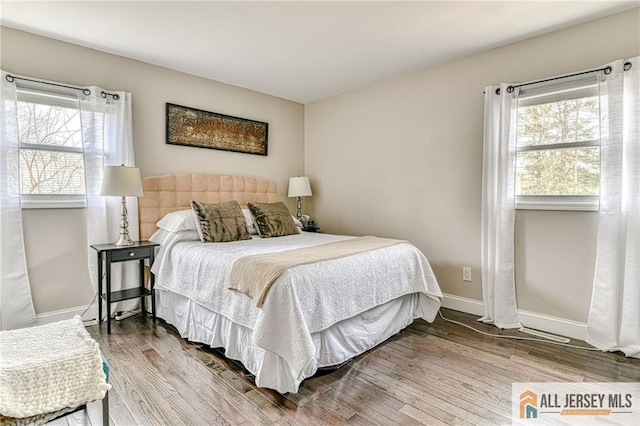 bedroom featuring wood finished floors and baseboards
