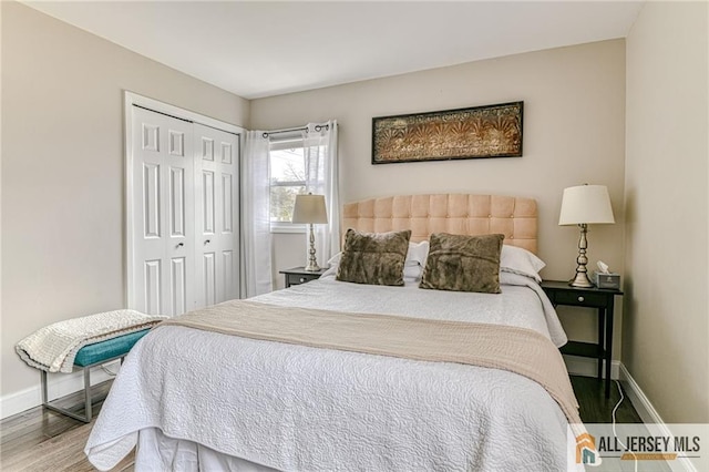 bedroom with baseboards, wood finished floors, and a closet