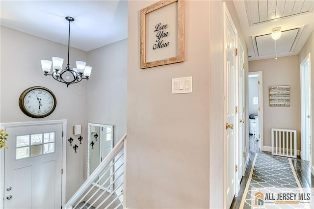 entrance foyer with radiator, baseboards, and a chandelier