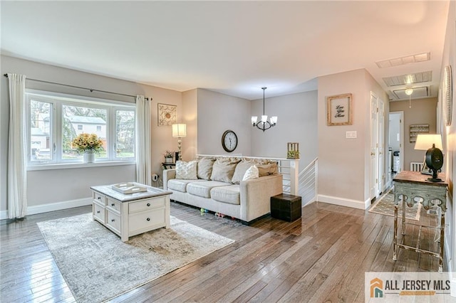 living room with attic access, hardwood / wood-style flooring, and baseboards