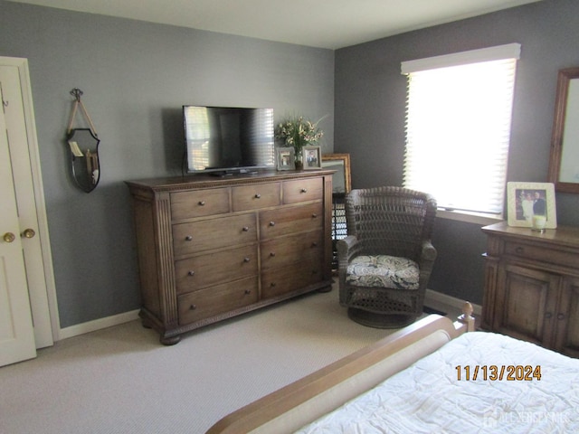 bedroom featuring baseboards and light colored carpet