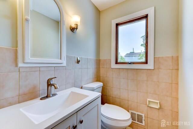21 Princeton Rd, Old Bridge, NJ 08859 - half bathroom featuring tile walls, vanity, and a wainscoted wall