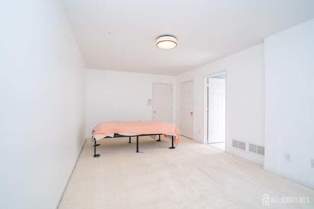 bedroom with visible vents and light carpet