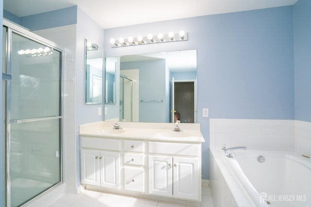 full bath with a sink, double vanity, a stall shower, tile patterned floors, and a garden tub