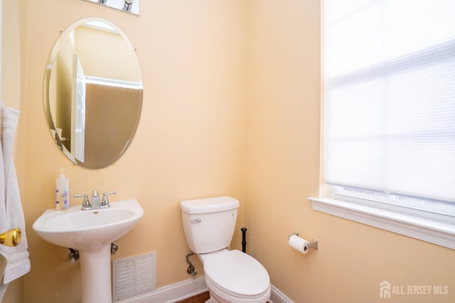 bathroom with baseboards, visible vents, and toilet