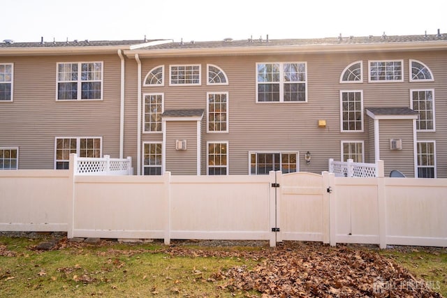 back of property with fence and a gate