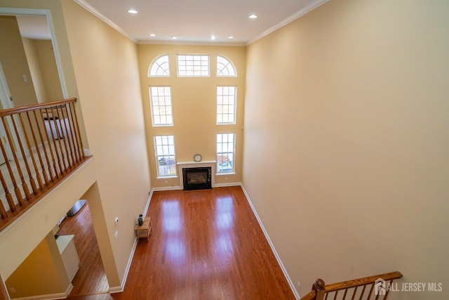 entryway with baseboards, wood finished floors, a wealth of natural light, and a fireplace with flush hearth