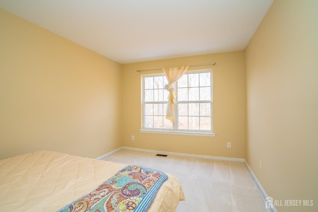 carpeted bedroom featuring visible vents and baseboards