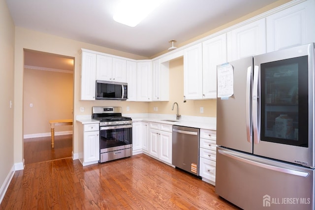 kitchen featuring white cabinetry, appliances with stainless steel finishes, light countertops, and a sink