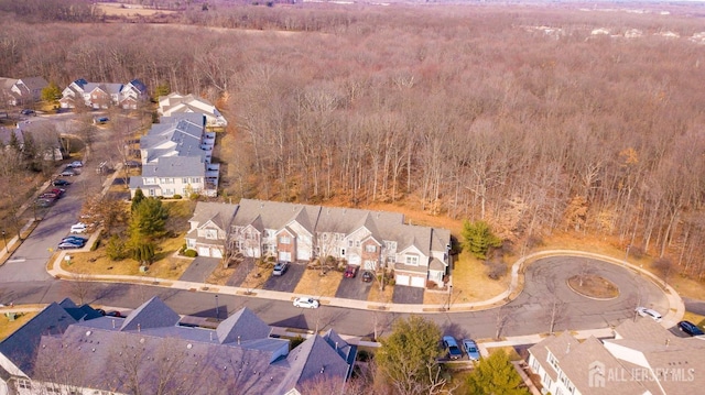 drone / aerial view featuring a residential view and a view of trees