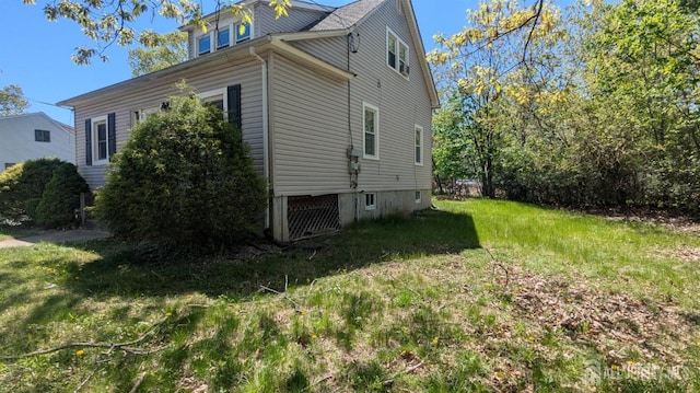 view of side of home with a yard