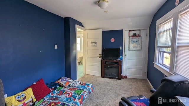 carpeted bedroom with lofted ceiling, multiple windows, and baseboards