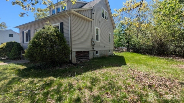 view of side of home with a lawn