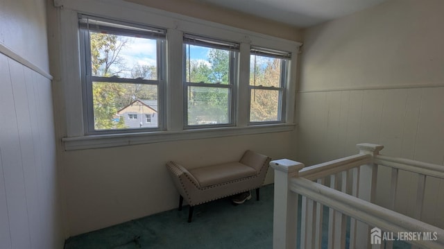 bedroom with carpet, wood walls, and a wainscoted wall