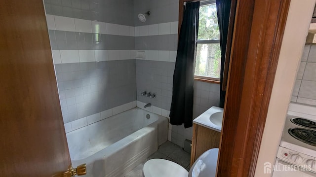 bathroom featuring shower / bath combination, toilet, vanity, tile patterned flooring, and tile walls