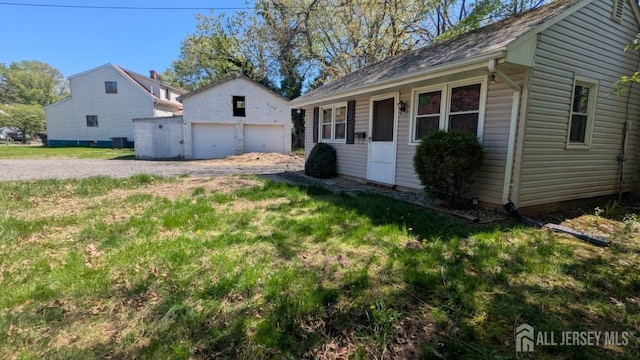 view of front facade with a garage, an outbuilding, and a front yard