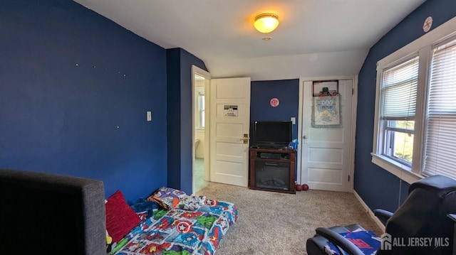 carpeted bedroom with multiple windows, lofted ceiling, and baseboards