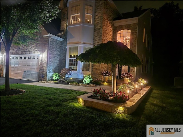 yard at twilight with a yard and asphalt driveway