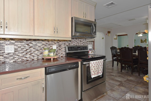 100 Woodland Ave, Fords, NJ 08863 - kitchen with stainless steel appliances, backsplash, arched walkways, ceiling fan, and dark countertops