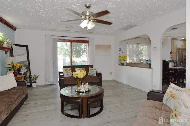 100 Woodland Ave, Fords, NJ 08863 - living area with light wood-type flooring, ceiling fan, a textured ceiling, and arched walkways