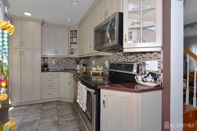 100 Woodland Ave, Fords, NJ 08863 - kitchen featuring stainless steel appliances, dark countertops, decorative backsplash, glass insert cabinets, and recessed lighting