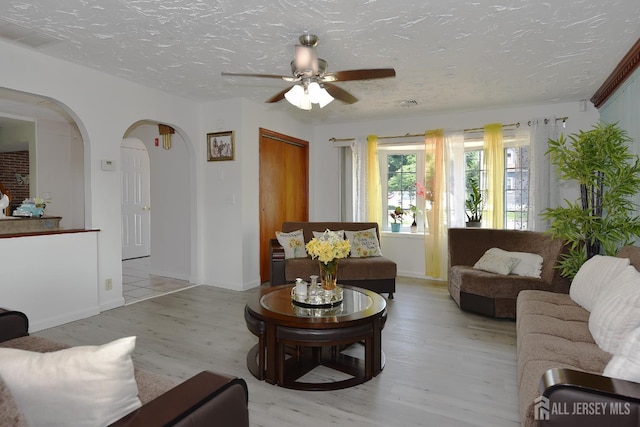 100 Woodland Ave, Fords, NJ 08863 - living room with light wood-style floors, arched walkways, ceiling fan, and a textured ceiling