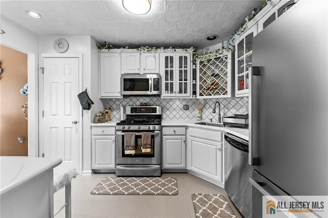 11 Rondell Ln, South Amboy, NJ 08879 - kitchen with appliances with stainless steel finishes, white cabinets, light countertops, glass insert cabinets, and backsplash