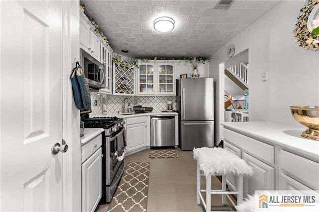 11 Rondell Ln, South Amboy, NJ 08879 - kitchen featuring stainless steel appliances, glass insert cabinets, white cabinets, and light countertops