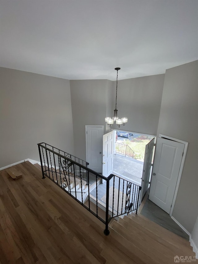 stairway featuring hardwood / wood-style floors and a chandelier