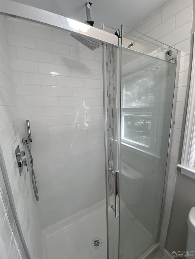 bathroom with an enclosed shower and toilet