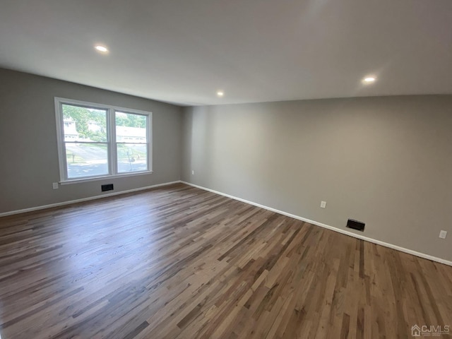 empty room with dark hardwood / wood-style flooring