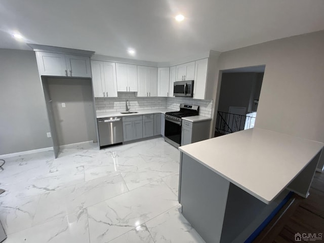 kitchen with sink, stainless steel appliances, backsplash, kitchen peninsula, and gray cabinets