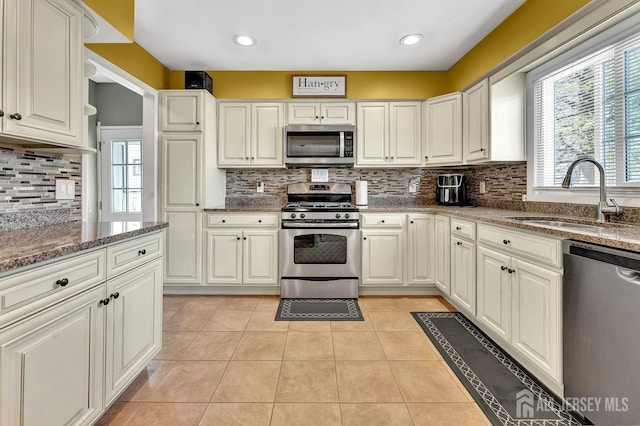 114 Jeffery Rd, Colonia, NJ 07067 - kitchen with stainless steel appliances, a sink, backsplash, light tile patterned flooring, and stone counters