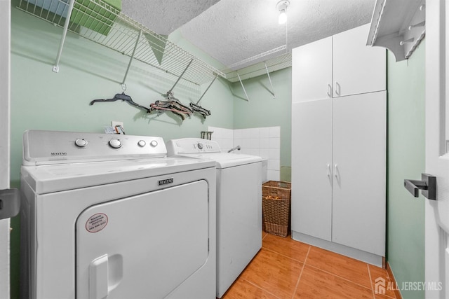 17 4th St, South River, NJ 08882 - washroom with cabinet space, washing machine and dryer, a textured ceiling, and light wood-type flooring