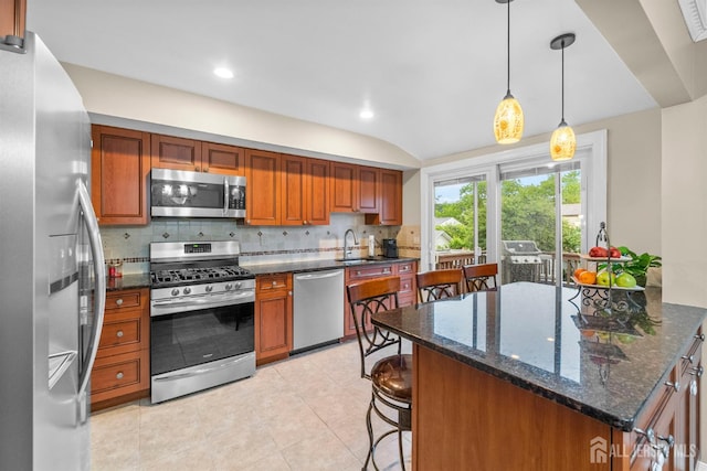 17 4th St, South River, NJ 08882 - kitchen featuring appliances with stainless steel finishes, decorative backsplash, a sink, a breakfast bar area, and light tile patterned floors