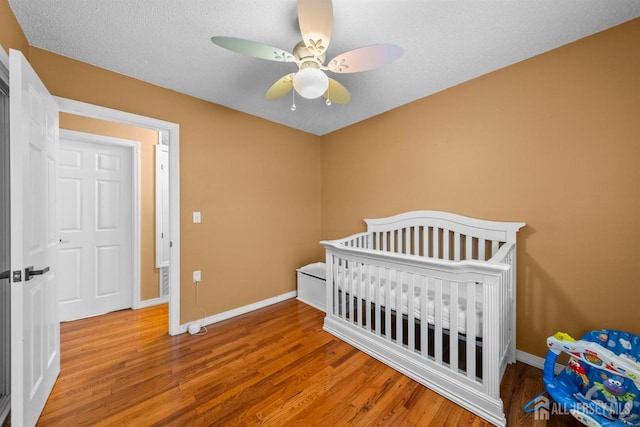 17 4th St, South River, NJ 08882 - bedroom featuring wood finished floors, baseboards, a ceiling fan, and a crib