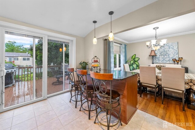 17 4th St, South River, NJ 08882 - kitchen with a chandelier, plenty of natural light, light tile patterned floors, a kitchen bar, and lofted ceiling