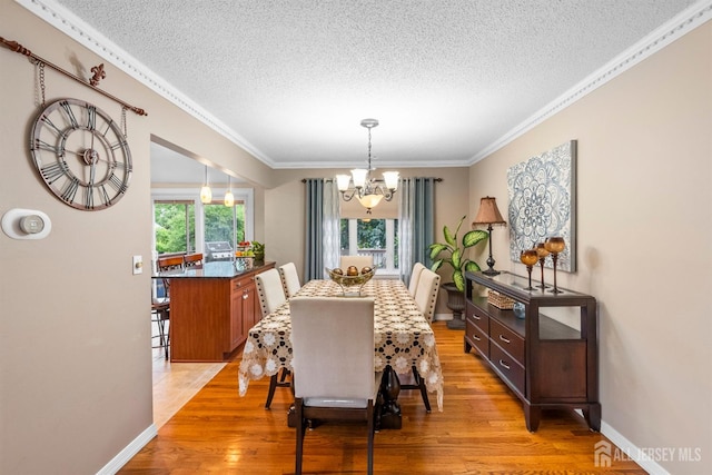 17 4th St, South River, NJ 08882 - dining space with a textured ceiling, a chandelier, ornamental molding, light wood-style floors, and baseboards