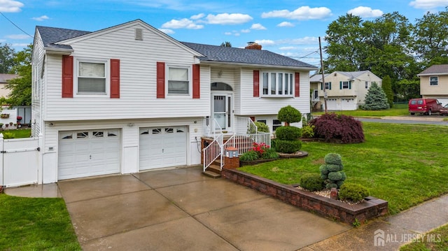 17 4th St, South River, NJ 08882 - bi-level home featuring a garage, driveway, a chimney, a front yard, and roof with shingles