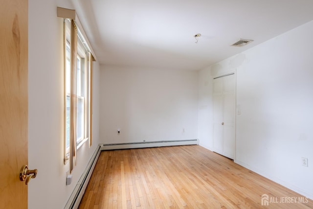 170 Jordon Rd, Colonia, NJ 07067 - unfurnished room with plenty of natural light, light wood-style flooring, baseboard heating, and a baseboard heating unit