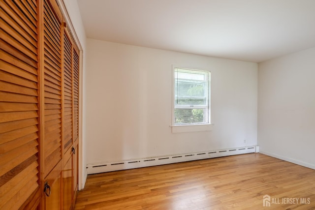 170 Jordon Rd, Colonia, NJ 07067 - unfurnished bedroom featuring baseboard heating, light wood-style flooring, a closet, and baseboards