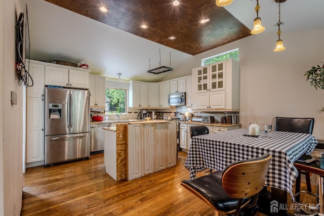170 Jordon Rd, Colonia, NJ 07067 - kitchen with appliances with stainless steel finishes, light wood finished floors, vaulted ceiling, backsplash, and a kitchen island