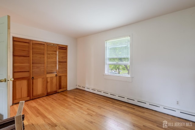 170 Jordon Rd, Colonia, NJ 07067 - unfurnished bedroom featuring a baseboard heating unit, light wood finished floors, and a closet
