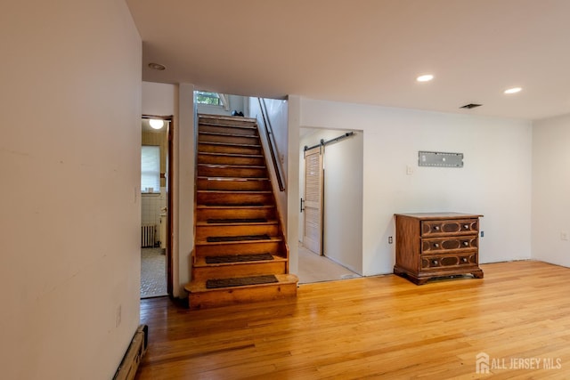 170 Jordon Rd, Colonia, NJ 07067 - stairway with radiator heating unit, a barn door, wood finished floors, and recessed lighting