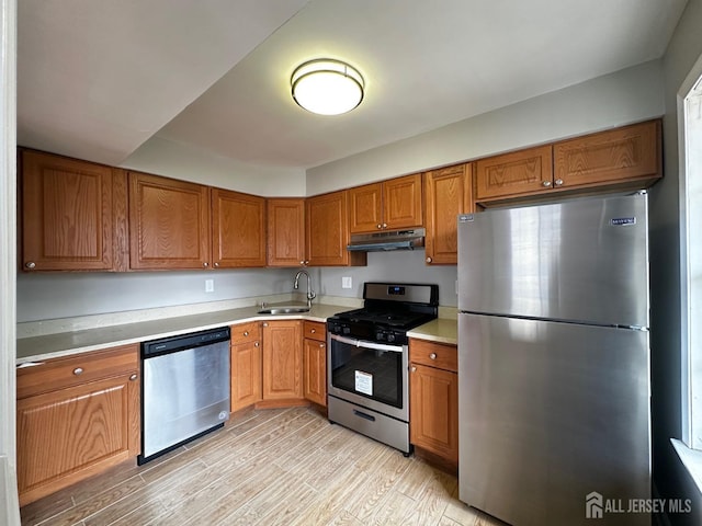158 Mill Run, Hightstown, NJ 08520 - kitchen with stainless steel appliances, under cabinet range hood, a sink, light wood-style flooring, and brown cabinetry