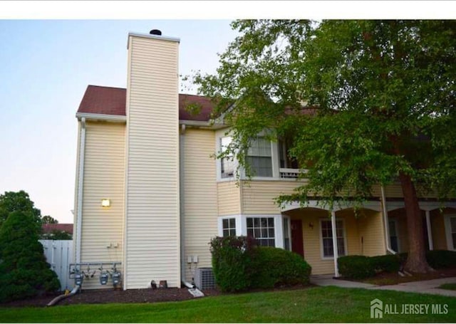 view of property exterior with a yard and a chimney