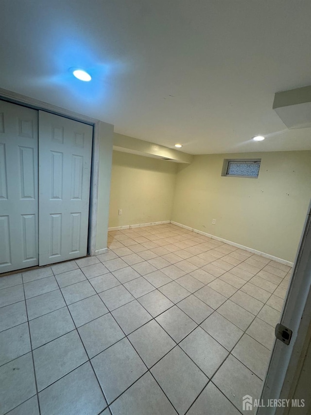 finished basement featuring recessed lighting, light tile patterned floors, and baseboards