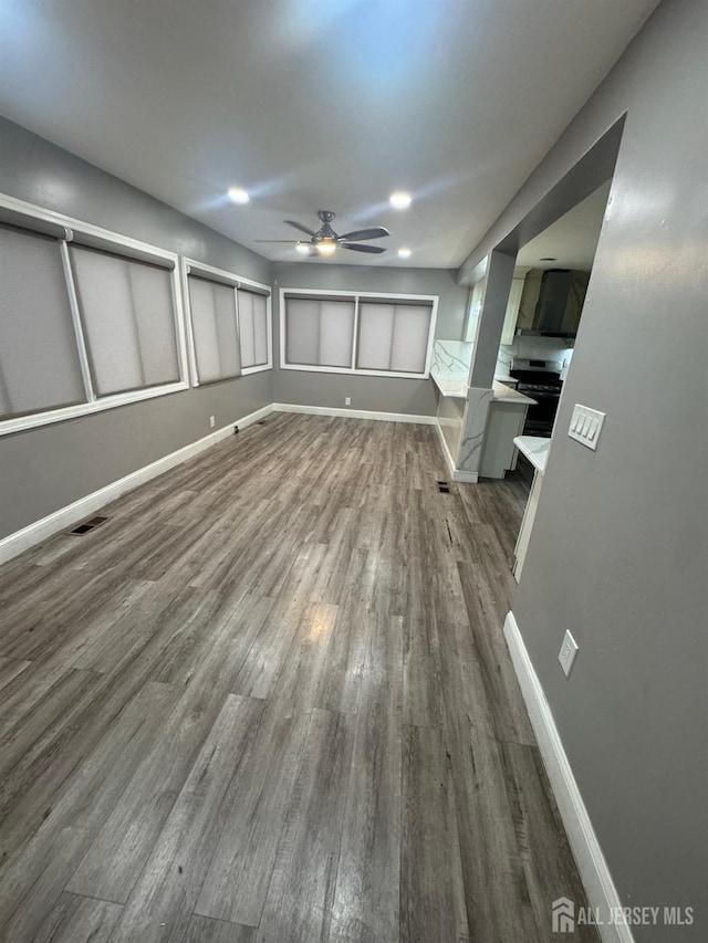 unfurnished living room featuring ceiling fan, wood finished floors, baseboards, and recessed lighting